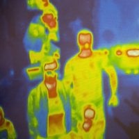 Thermal scanner / camera detecting infected people with Covid-19. Group of people under thermal imaging camera. Modern airport checking system.